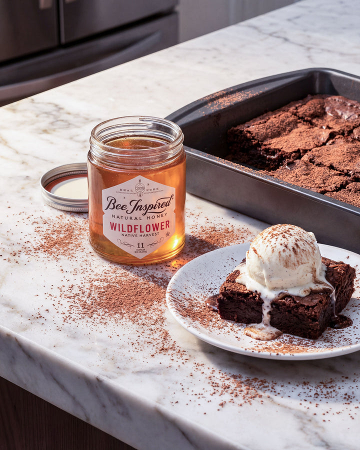 Jar of 'Bee Inspired' wildflower honey on a kitchen counter with brownies and ice cream.