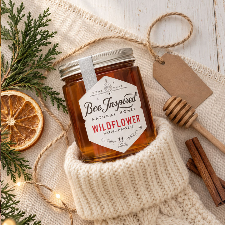 wildflower honey as holiday stocking stuffer with holiday greenery orange wheen, cinnamon stick and honey dipper