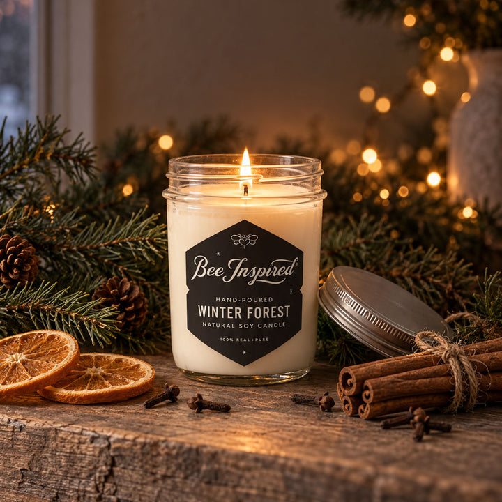bee inspired winter forest candle with holiday greenery on wood surface