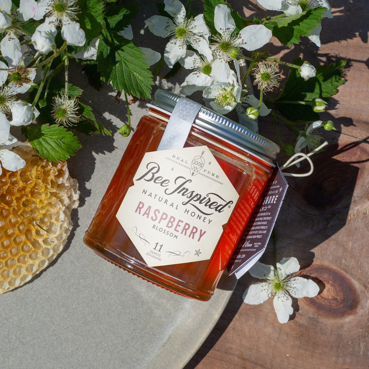 raspberry honey with raw wax and flowering raspberries
