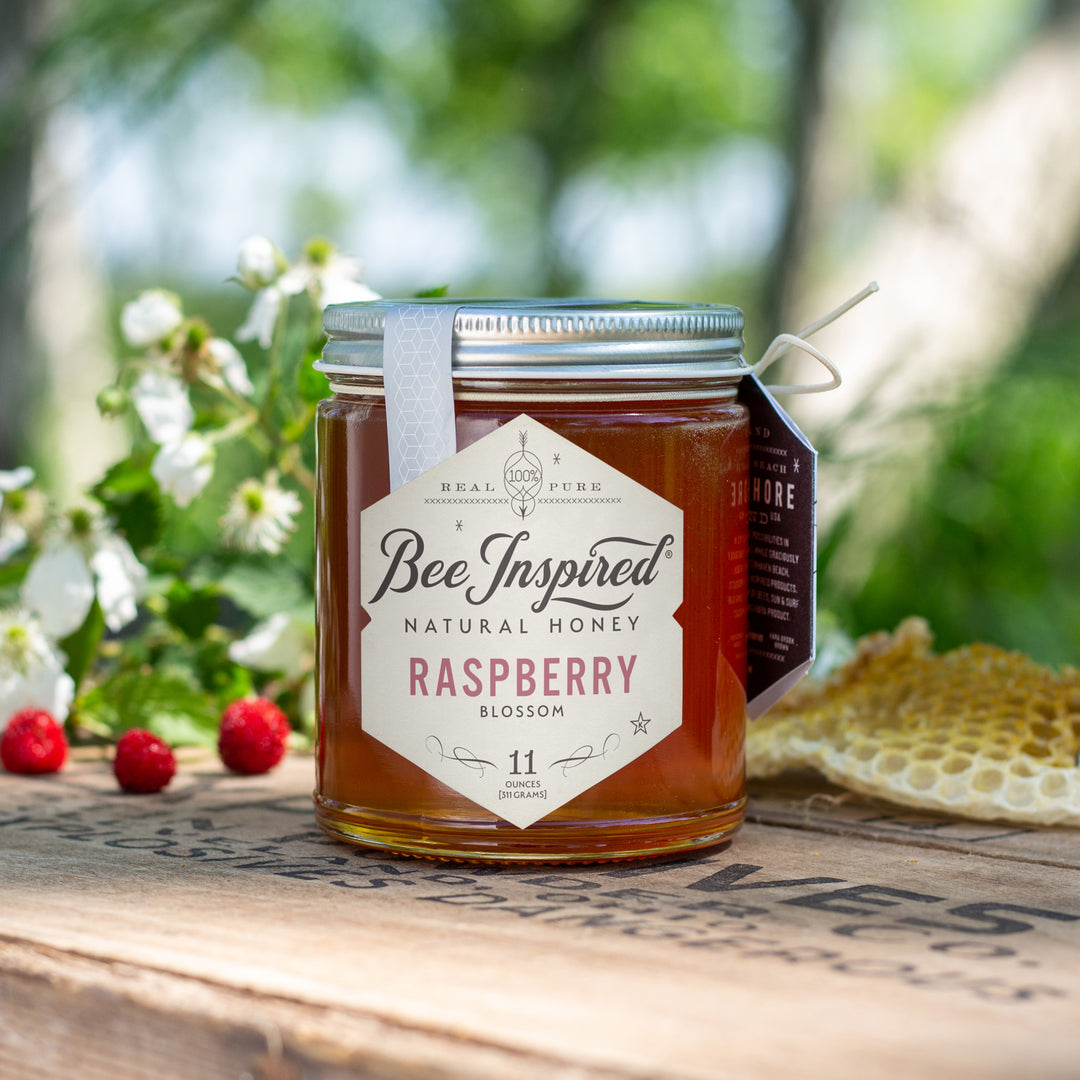 raspberry honey on set outdoors with raspberries